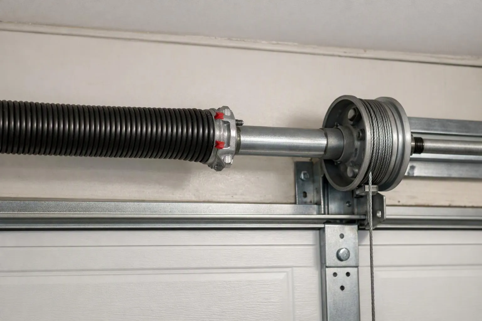 Torsion spring and cable drum above a garage door